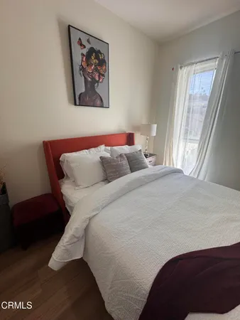 a bedroom with a bed and a painting on the wall