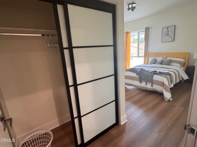 a bedroom with a bed and a refrigerator