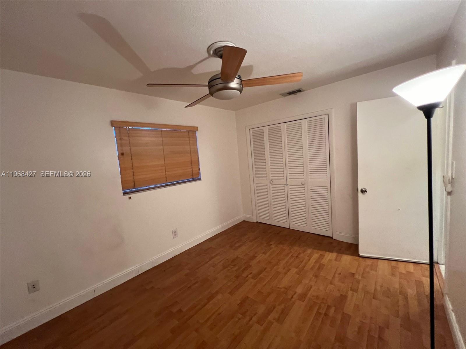 344 Southwest 1st Street, Unit 6 Pompano Beach, FL 33060 - Photo 11 of 11 an empty room with wooden floor ceiling fan