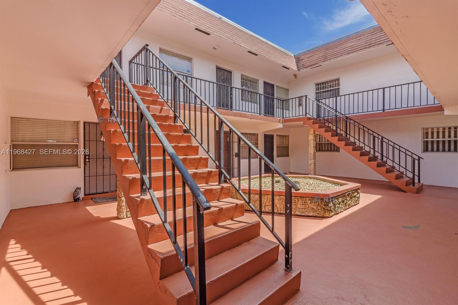 344 Southwest 1st Street, Unit 6 Pompano Beach, FL 33060 - Photo 4 of 11 a view of staircase with white walls and a wooden floor