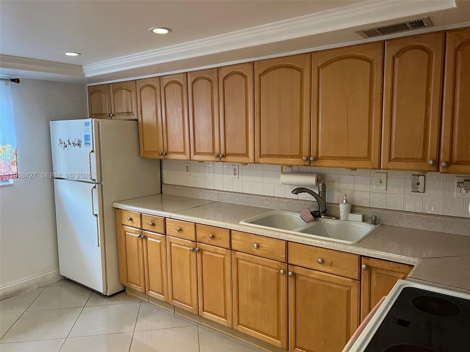 344 Southwest 1st Street, Unit 6 Pompano Beach, FL 33060 - Photo 5 of 11 a kitchen with stainless steel appliances granite countertop a refrigerator a sink and white cabinets