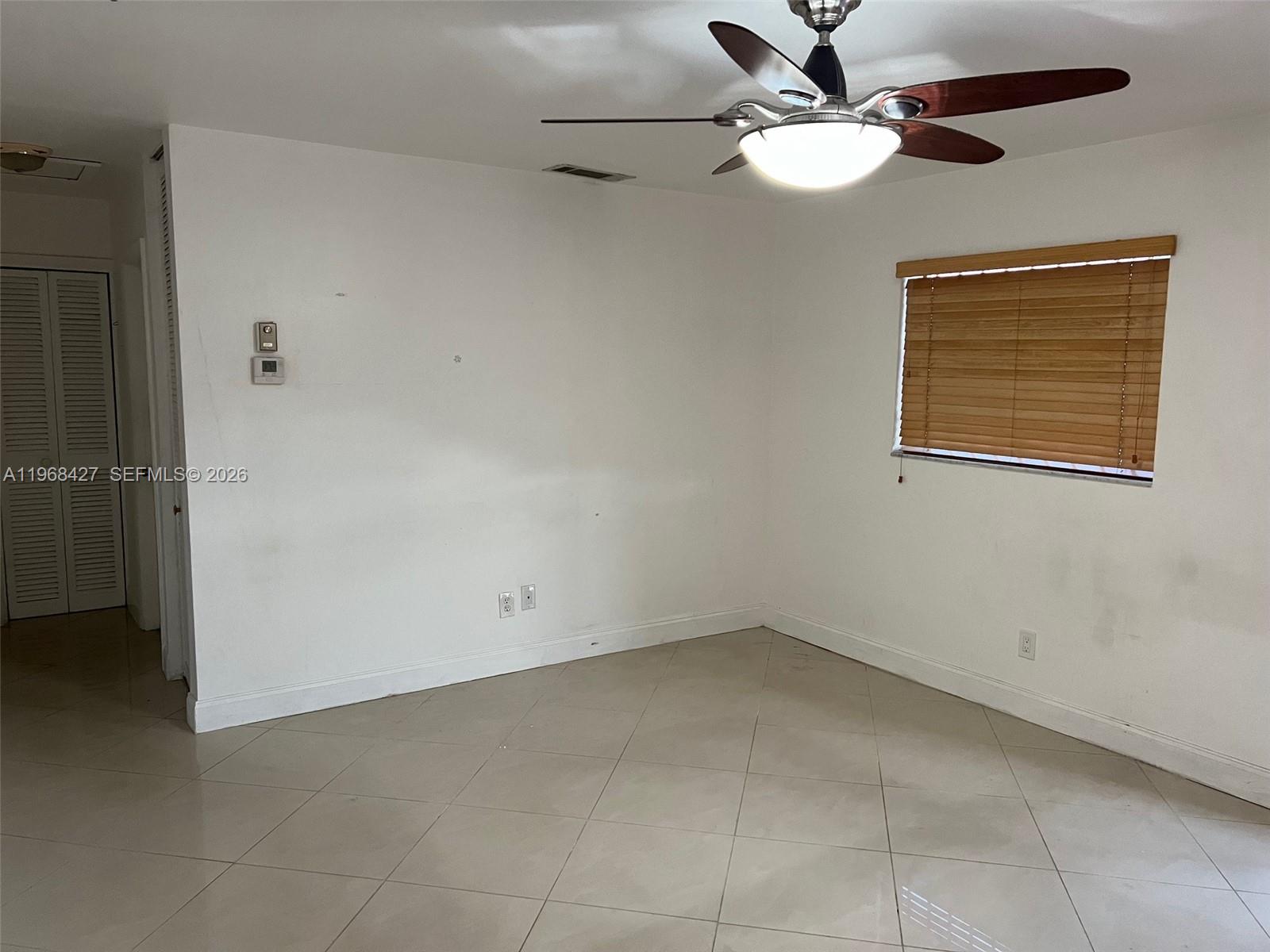 344 Southwest 1st Street, Unit 6 Pompano Beach, FL 33060 - Photo 6 of 11 an empty room with a ceiling fan and a window