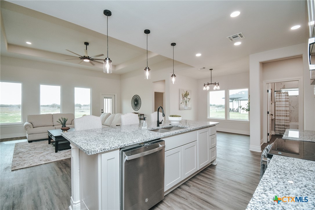 321 Whitetail Lane Victoria, TX 77905 - Photo 10 of 47 a kitchen with center island a sink dishwasher a dining table and chairs with wooden floor