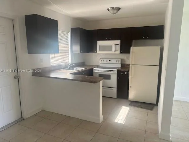 a kitchen with a sink a refrigerator and cabinets