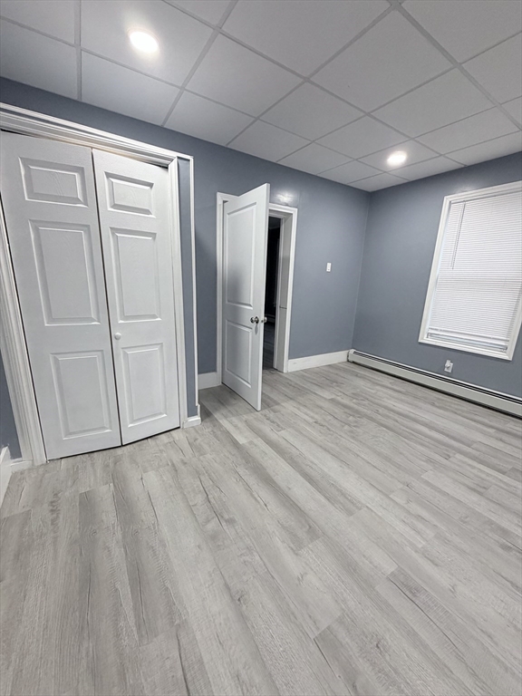 143 Cambridge Street, Unit 2 Worcester, MA 01603 - Photo 4 of 9 a view of an empty room with wooden floor and a window