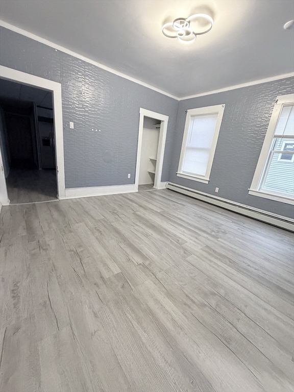 143 Cambridge Street, Unit 2 Worcester, MA 01603 - Photo 5 of 9 a view of an empty room with wooden floor and kitchen view