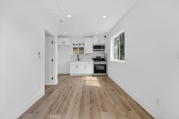 a view of kitchen with wooden floor and electronic appliances