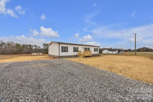 a front view of a house with a yard and lake view