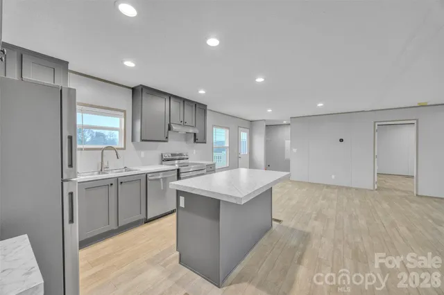 a kitchen with kitchen island sink stove and refrigerator