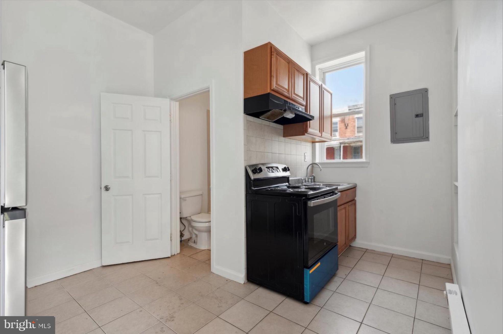 59 North 59th Street Philadelphia, PA 19139 - Photo 13 of 15 a kitchen with stainless steel appliances granite countertop a stove and a refrigerator