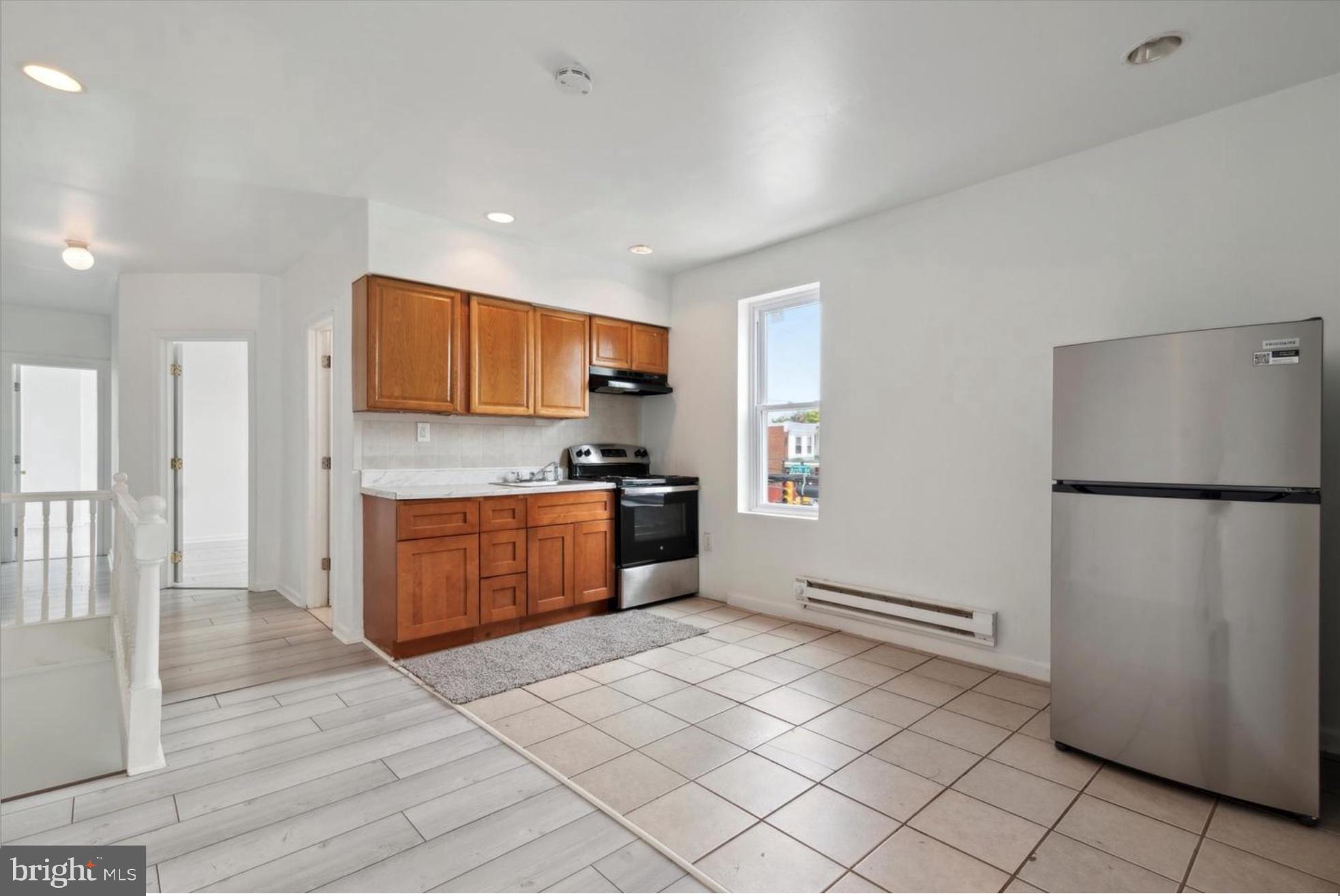 59 North 59th Street Philadelphia, PA 19139 - Photo 7 of 15 a kitchen with a refrigerator sink and cabinets