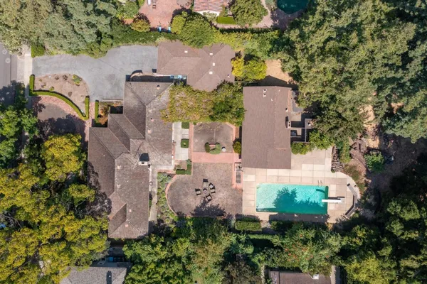 an aerial view of a house with a yard and a large tree