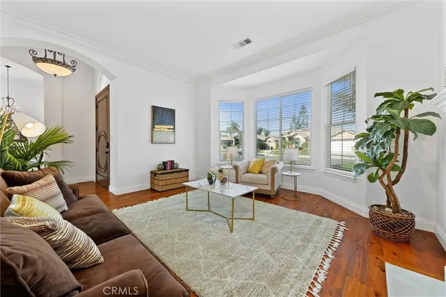 a view of a dining room with furniture a chandelier and wooden floor