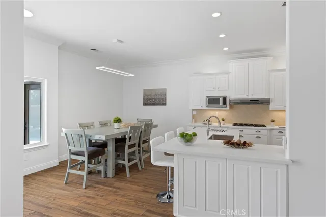 a kitchen with stainless steel appliances white cabinets and a stove a oven with white countertops