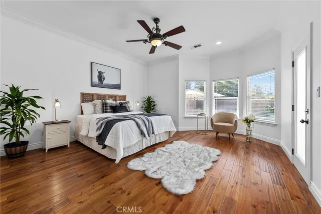 a spacious en suite bathroom with a granite countertop sink a toilet a mirror and vanity