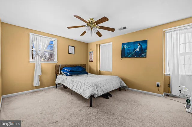 a view of a livingroom with a staircase a ceiling fan and a hardwood floor