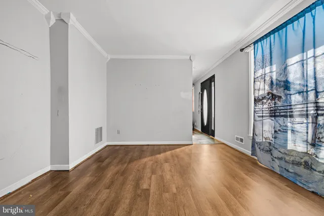 a view of an empty room with wooden floor