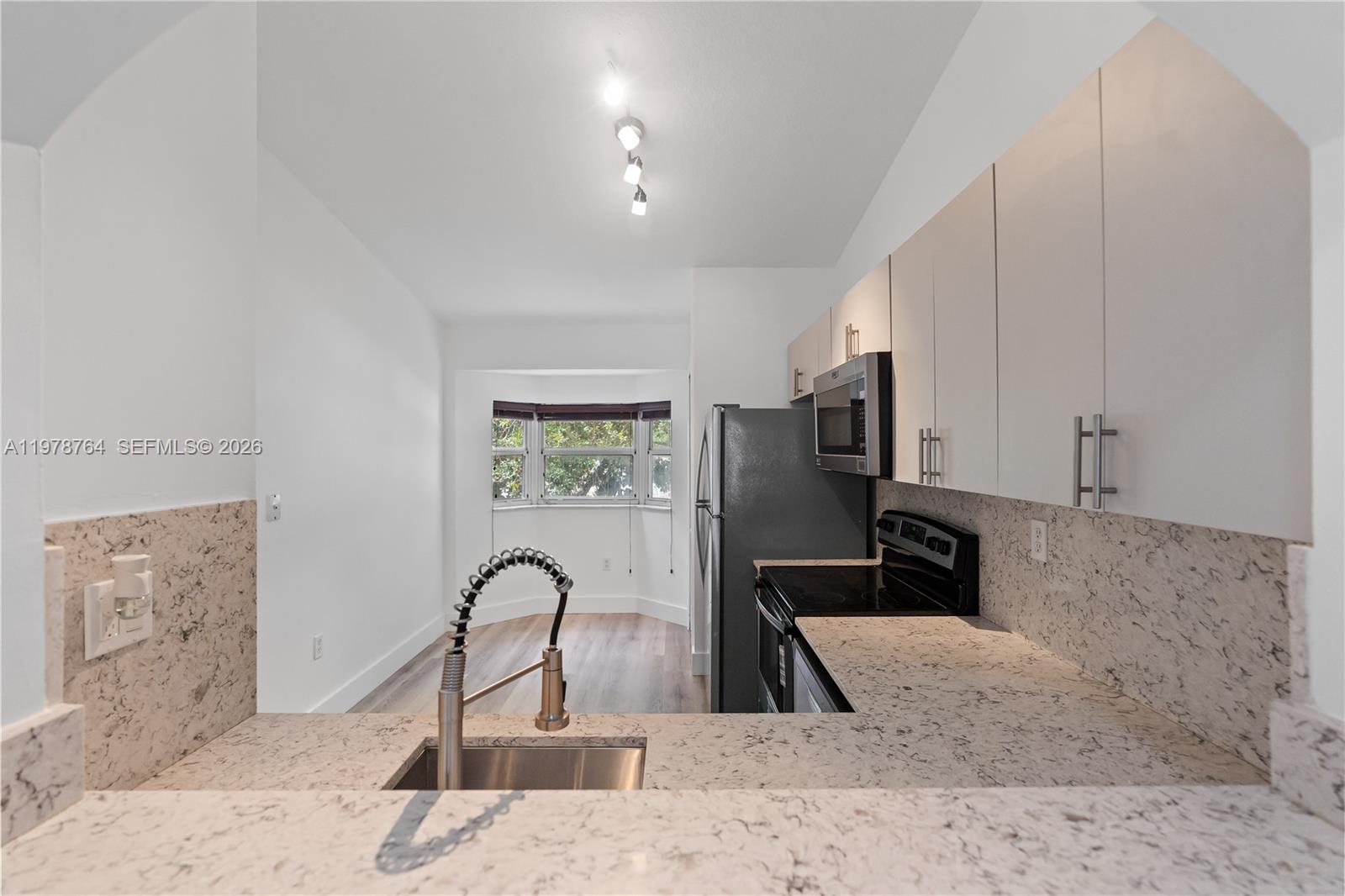2930 Southeast 12th Road, Unit 20431 Homestead, FL 33035 - Photo 21 of 33 a kitchen with stainless steel appliances kitchen island a stove a sink and a refrigerator