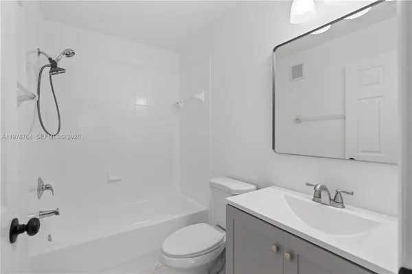 a bathroom with a granite countertop sink a toilet and shower