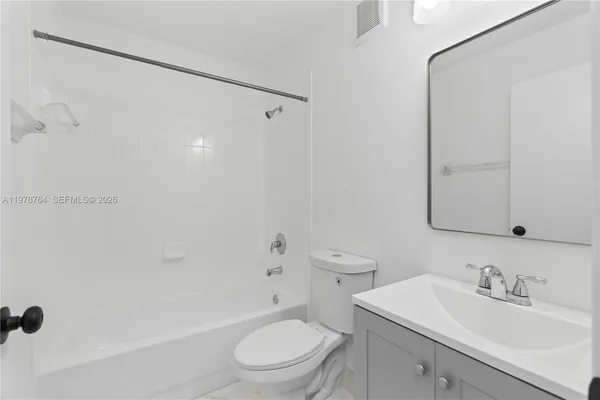 a bathroom with a toilet a sink a mirror a shower and vanity