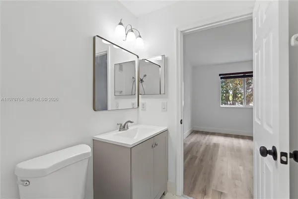 a bathroom with a toilet sink and mirror