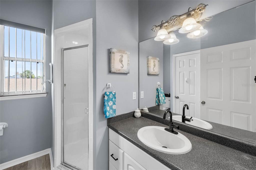 4464 Neptune Drive Hernando Beach, FL 34607 - Photo 27 of 47 a bathroom with a granite countertop sink and a mirror