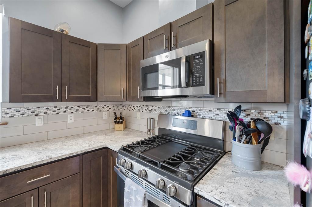 4464 Neptune Drive Hernando Beach, FL 34607 - Photo 9 of 47 a kitchen with stainless steel appliances granite countertop a sink stove and cabinets
