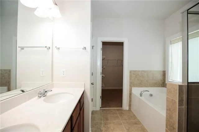 a bathroom with a tub sink and mirror