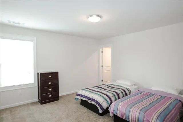 a bedroom with two bed and a dresser