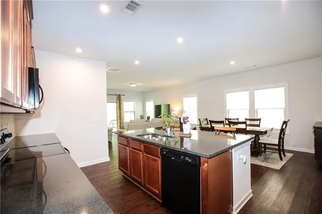 a kitchen with a counter top space a sink appliances and cabinets
