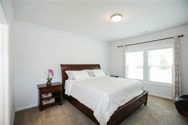 a bed sitting in a bedroom next to a window