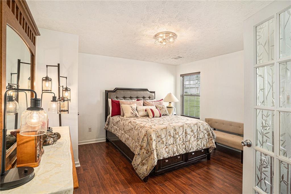 10897 Paladin Drive Hampton, GA 30228 - Photo 25 of 32 a bedroom with a bed and wooden floor