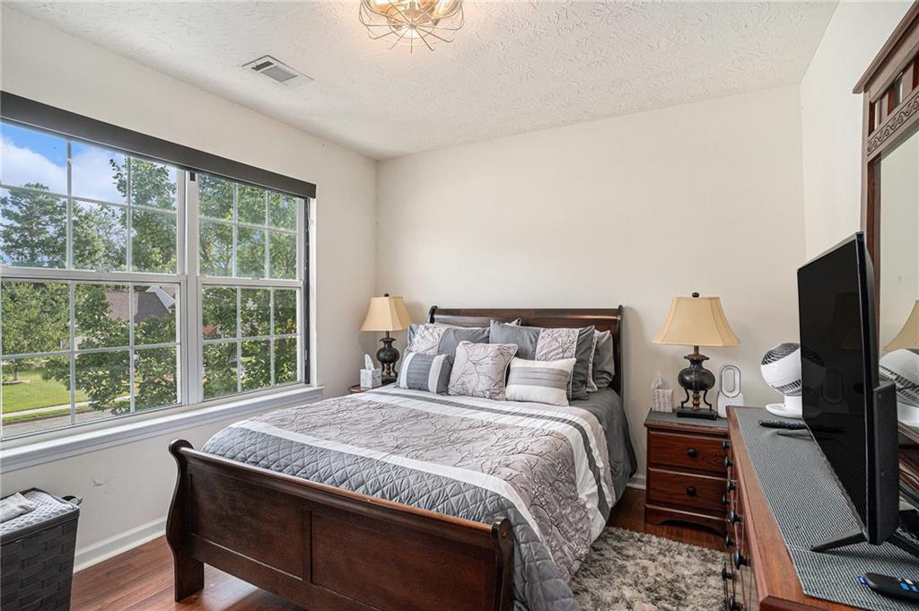 10897 Paladin Drive Hampton, GA 30228 - Photo 27 of 32 a bedroom with a large bed and a flat tv screen on dresser
