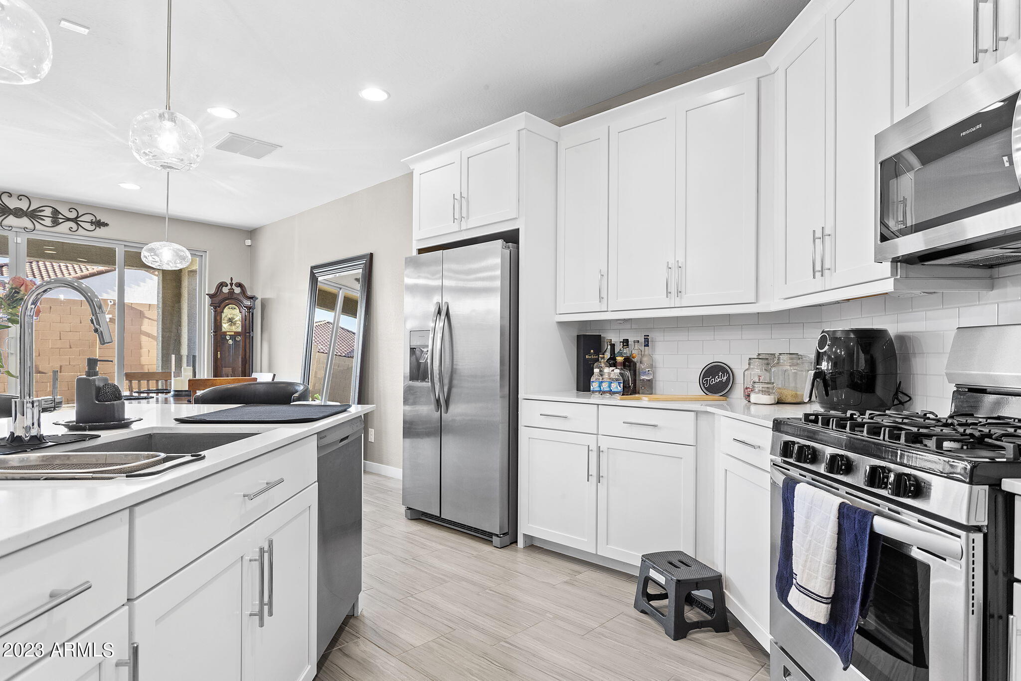 12356 East Soloman Road Gold Canyon, AZ 85118 - Photo 11 of 53 a kitchen with stainless steel appliances granite countertop a stove a sink dishwasher a refrigerator and white cabinets with wooden floor