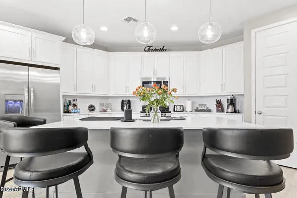 a kitchen with stainless steel appliances white cabinets and a stove top oven