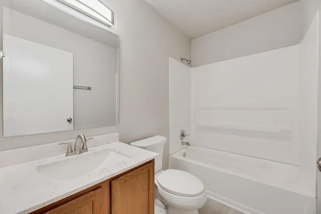a bathroom with a sink toilet vanity and shower