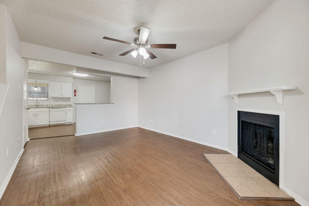 648 South Rogers Road, Unit 648 Irving, TX 75060 - Photo 3 of 20 an empty room with wooden floor fireplace and windows