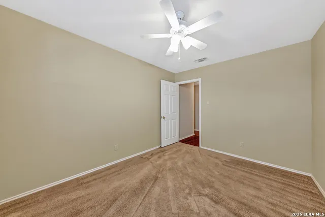 an empty room with a chandelier fan