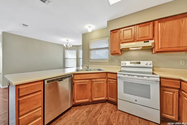 a kitchen with granite countertop cabinets stainless steel appliances and sink