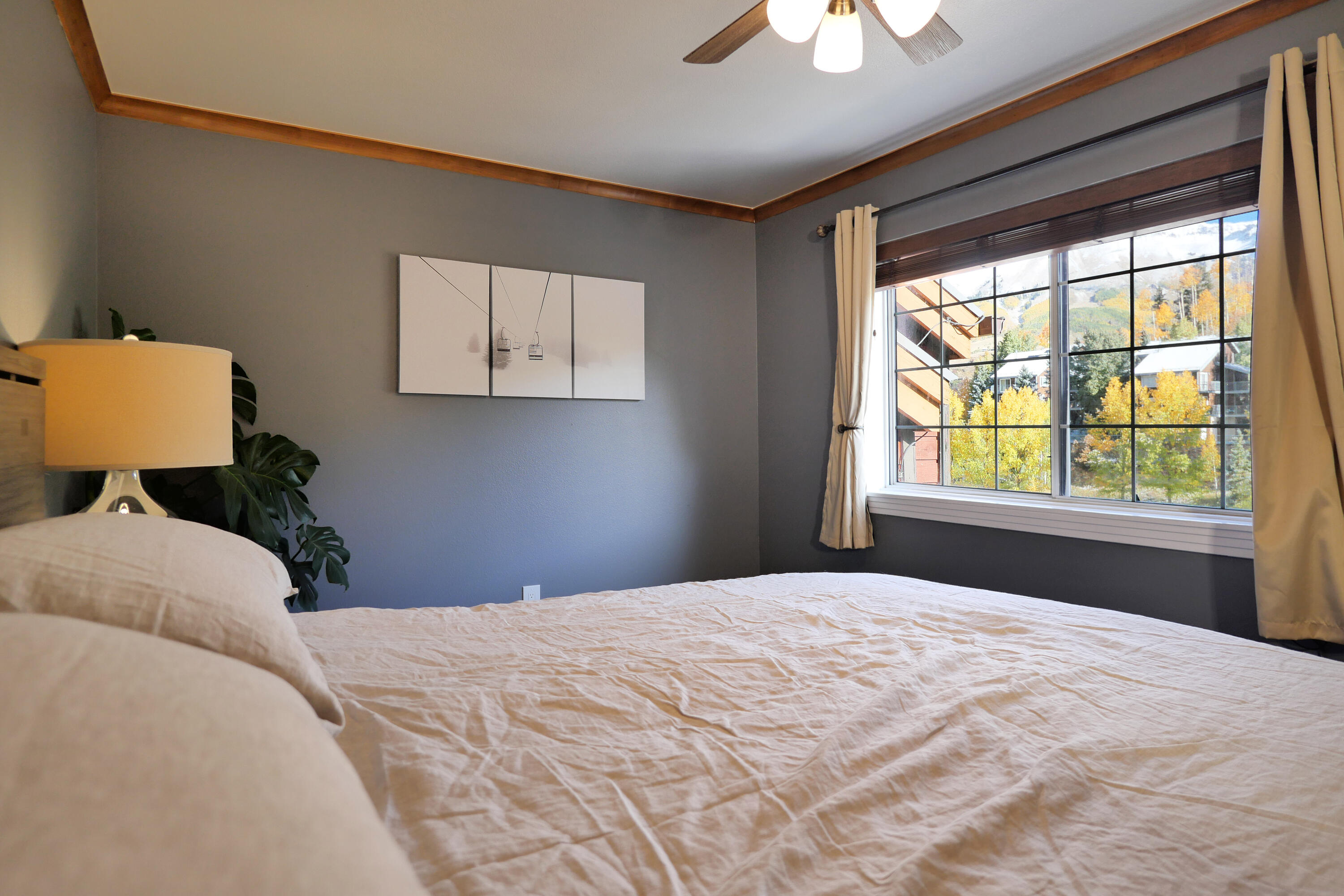 302 Adams Ranch Road, Unit 6 Mountain Village, CO 81435 - Photo 25 of 45 a bedroom with a large bed and a chandelier