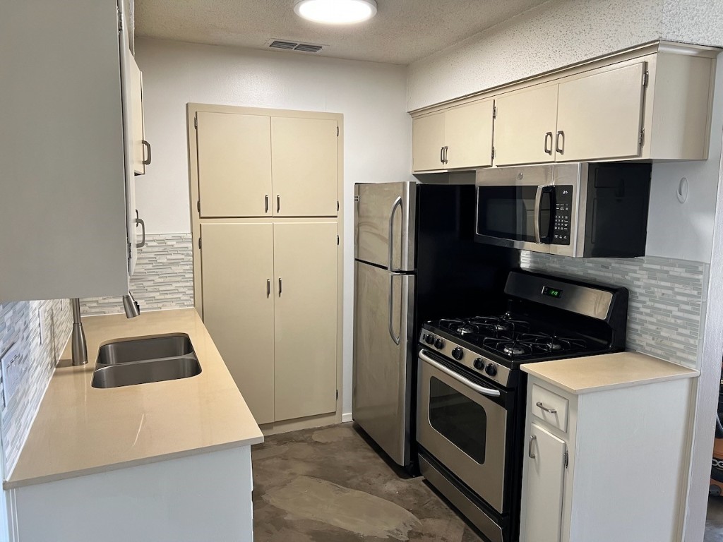 8005 Pinedale Cove, Unit B Austin, TX 78757 - Photo 3 of 22 a kitchen with cabinets and steel appliances