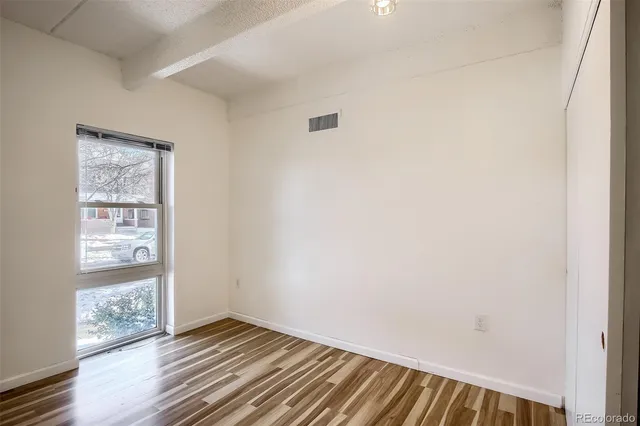 a view of a livingroom with wooden floor and white walls