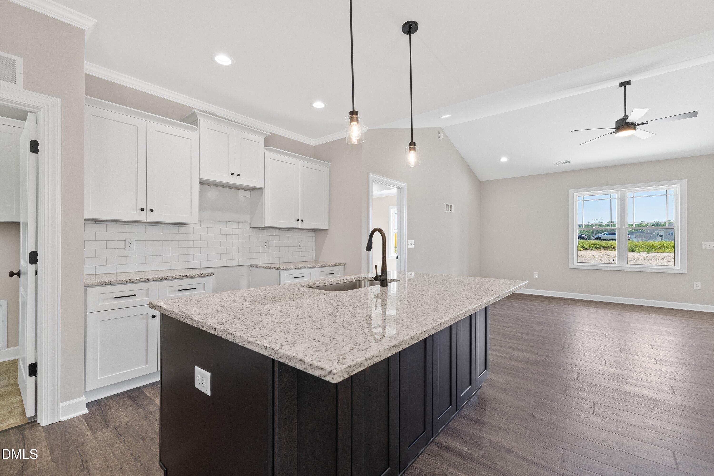 1061 Nor-Am Road Pikeville, NC 27863 - Photo 15 of 39 a kitchen with a stove center island cabinets and wooden floor