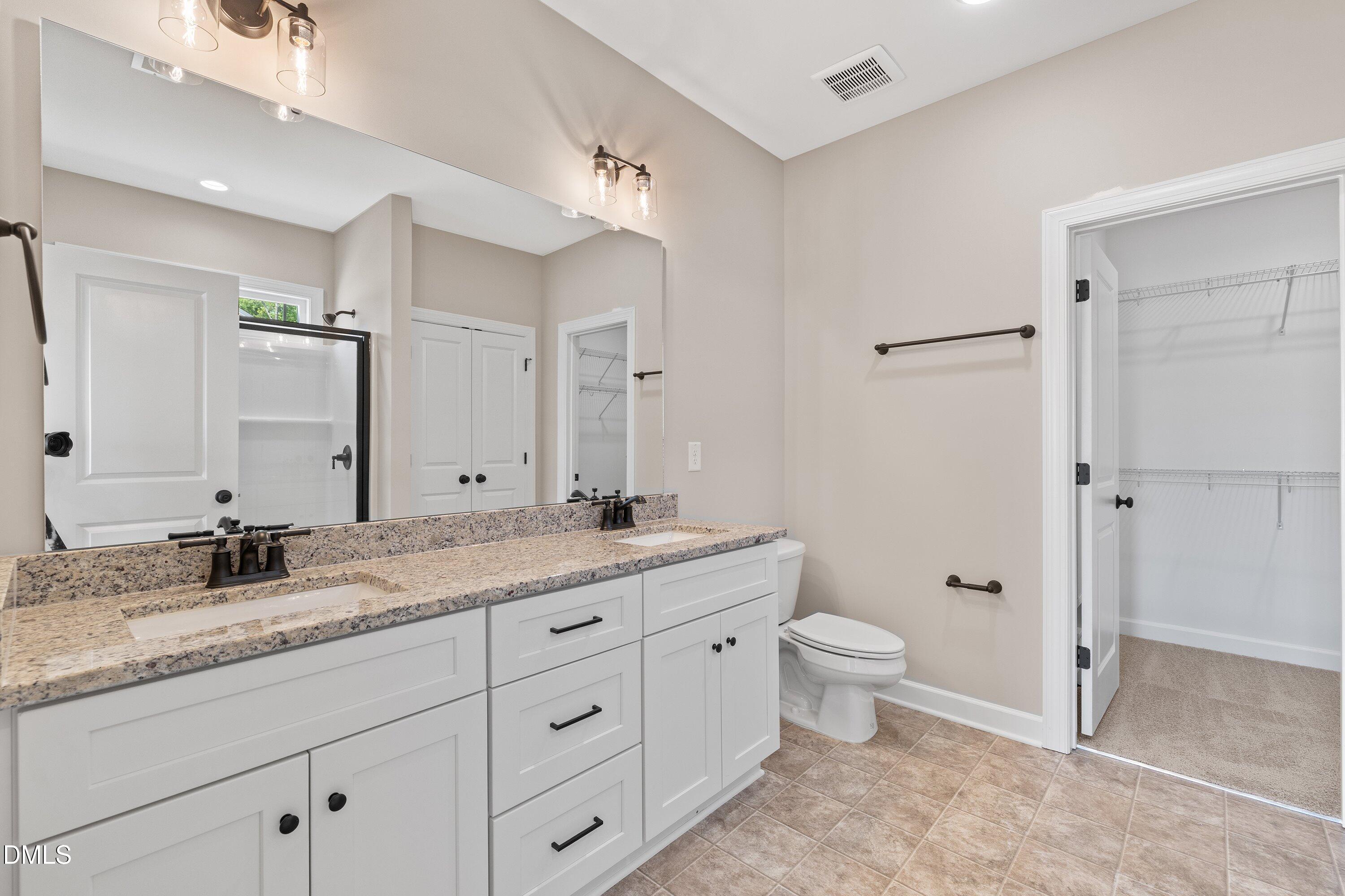 1061 Nor-Am Road Pikeville, NC 27863 - Photo 25 of 39 a bathroom with a granite countertop sink a toilet and a large mirror