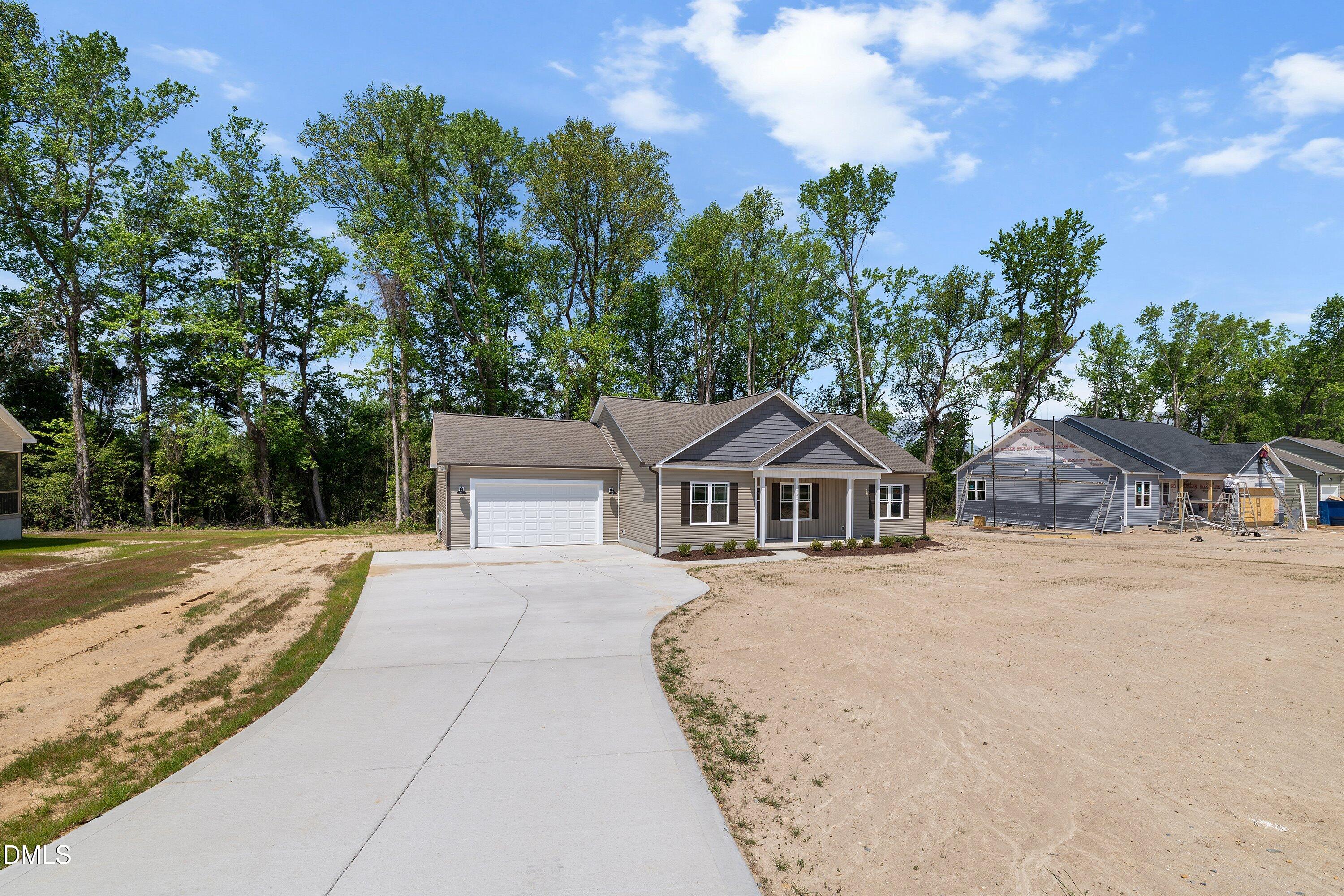 1061 Nor-Am Road Pikeville, NC 27863 - Photo 2 of 39 a front view of a house with a yard and trees