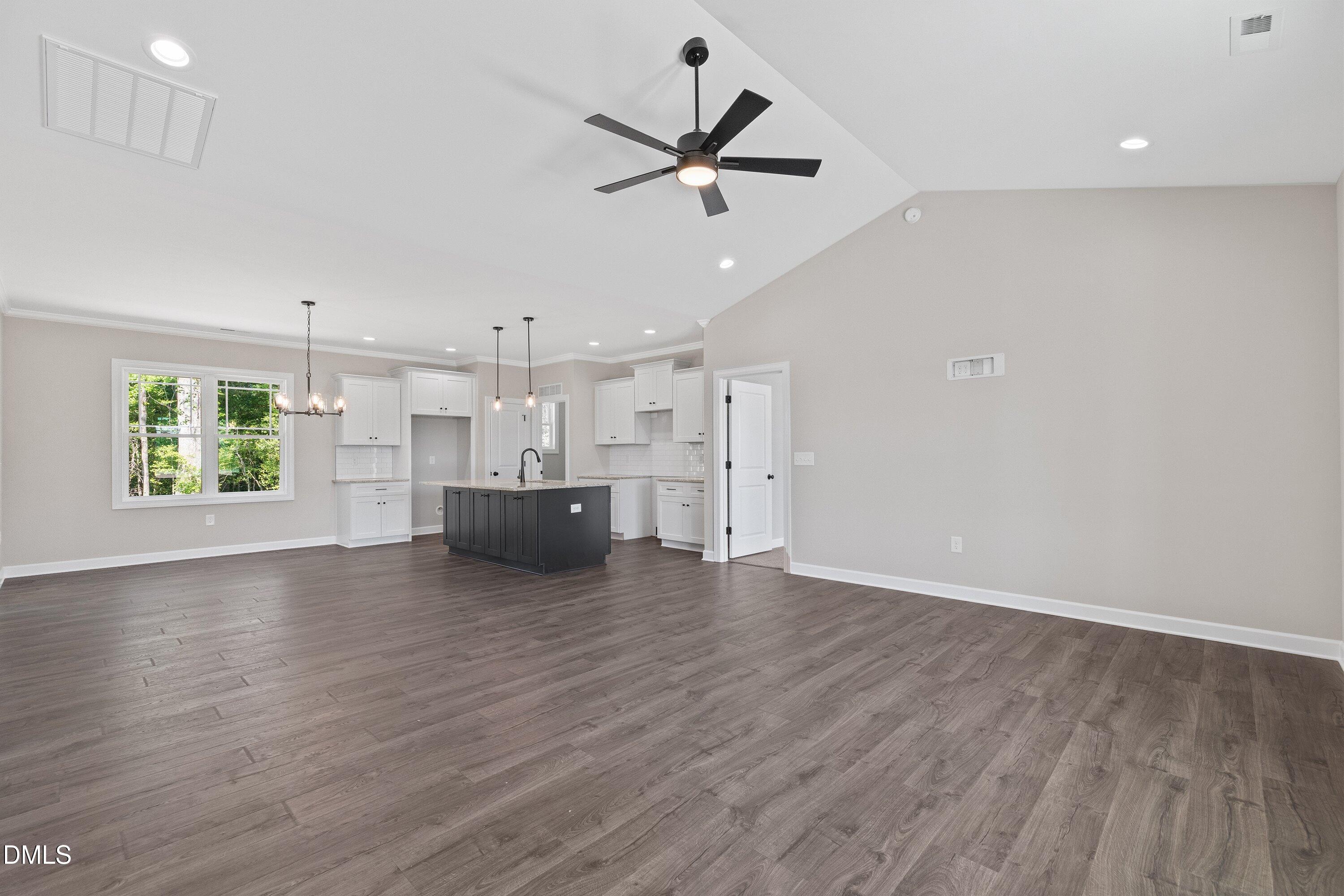 1061 Nor-Am Road Pikeville, NC 27863 - Photo 7 of 39 an empty room with wooden floor a ceiling fan and windows