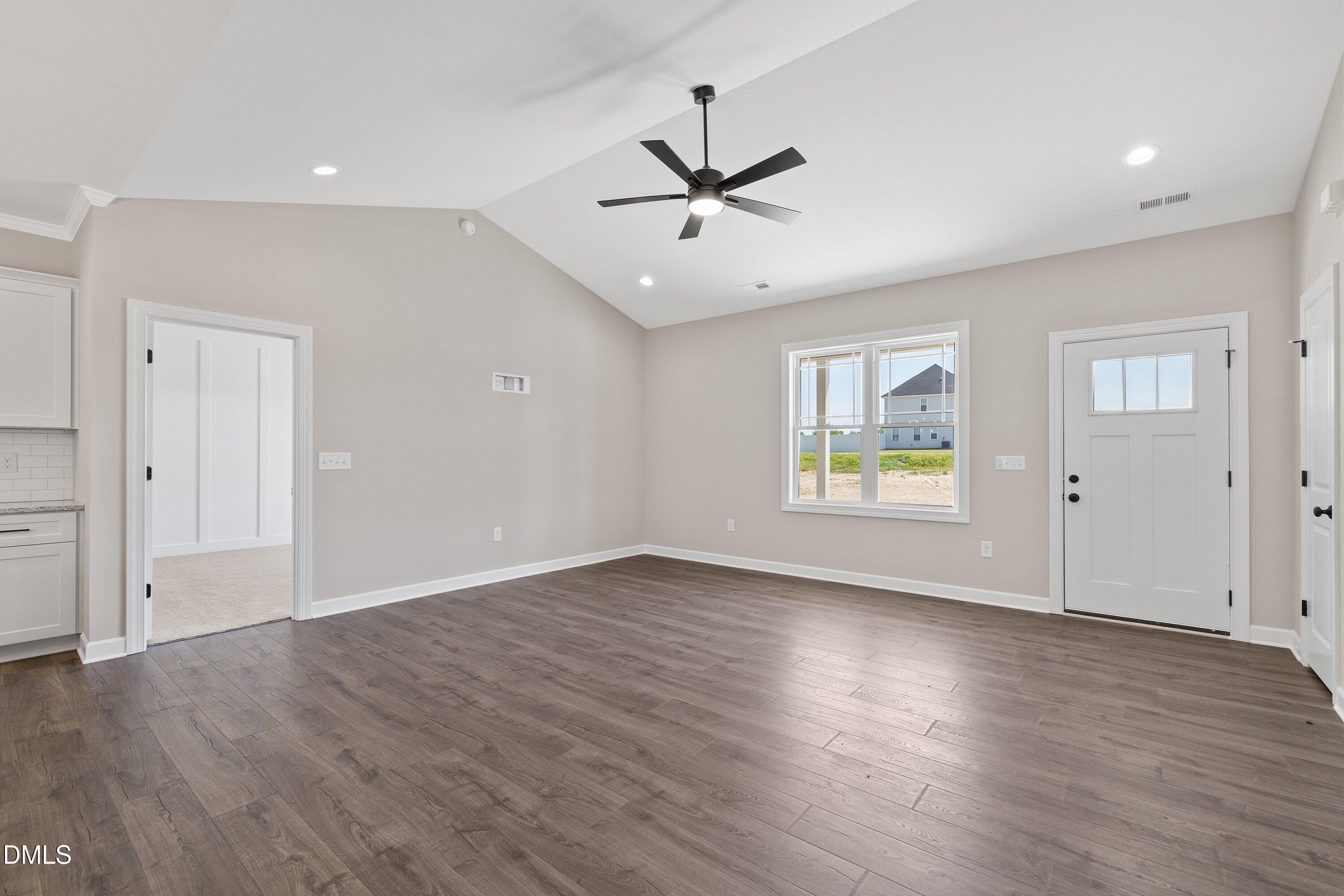 1061 Nor-Am Road Pikeville, NC 27863 - Photo 8 of 39 an empty room with wooden floor ceiling fan and windows