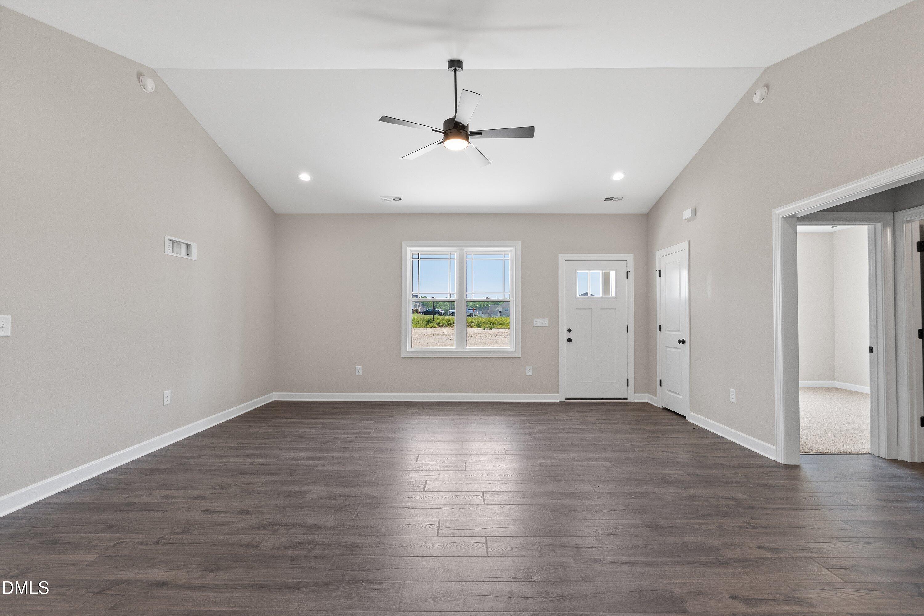 1061 Nor-Am Road Pikeville, NC 27863 - Photo 9 of 39 an empty room with wooden floor ceiling fan and windows