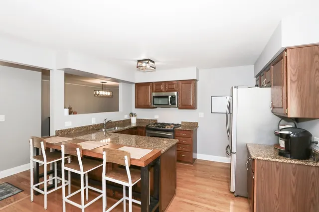 a kitchen with granite countertop a sink stove and refrigerator