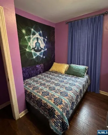 a bedroom with a bed and painting on the wall